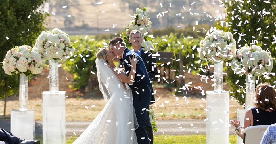 Confetti kiss following their vows